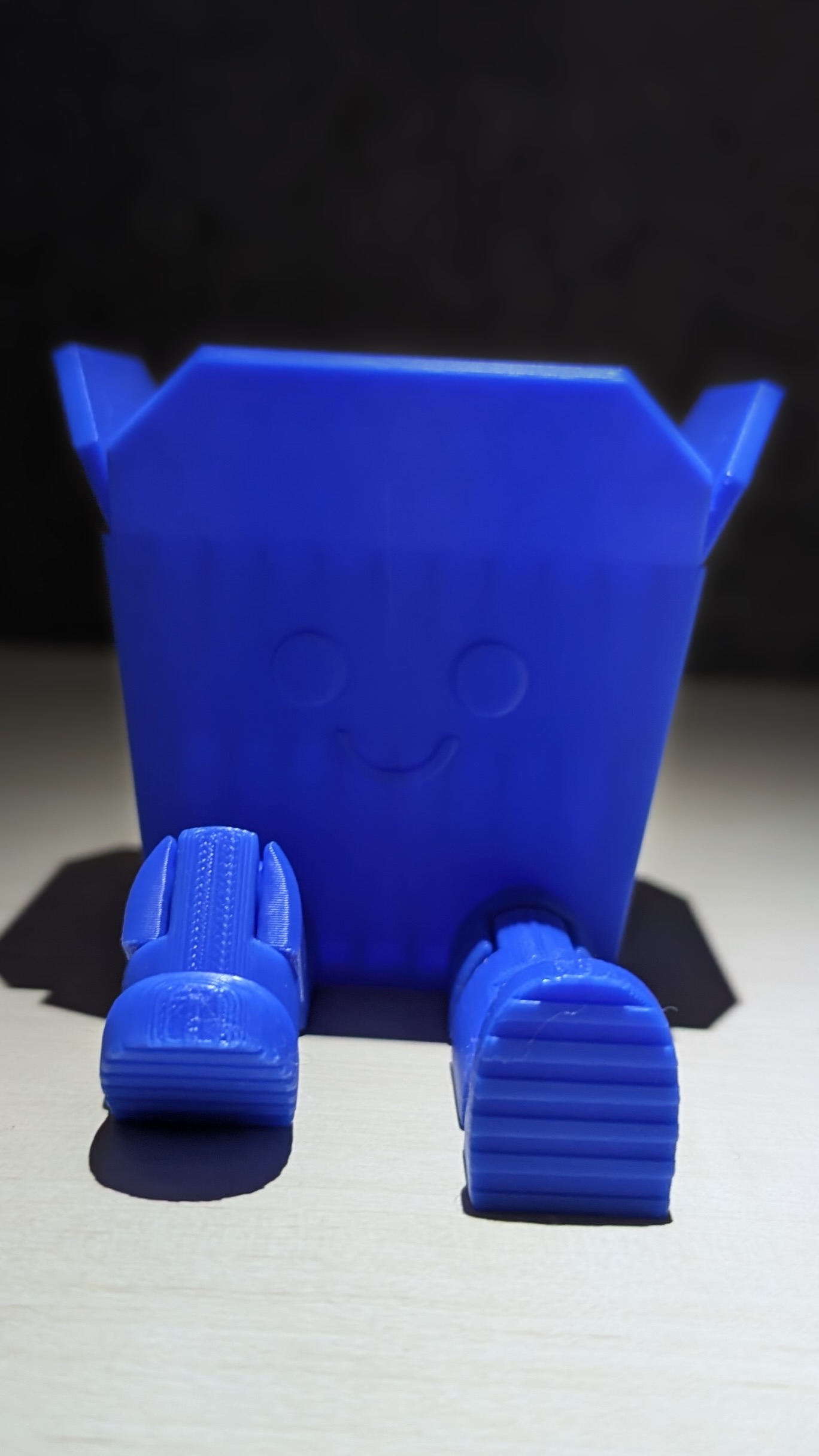 Eckiger Organizer in Blau mit Gesicht und beweglichen Beinen