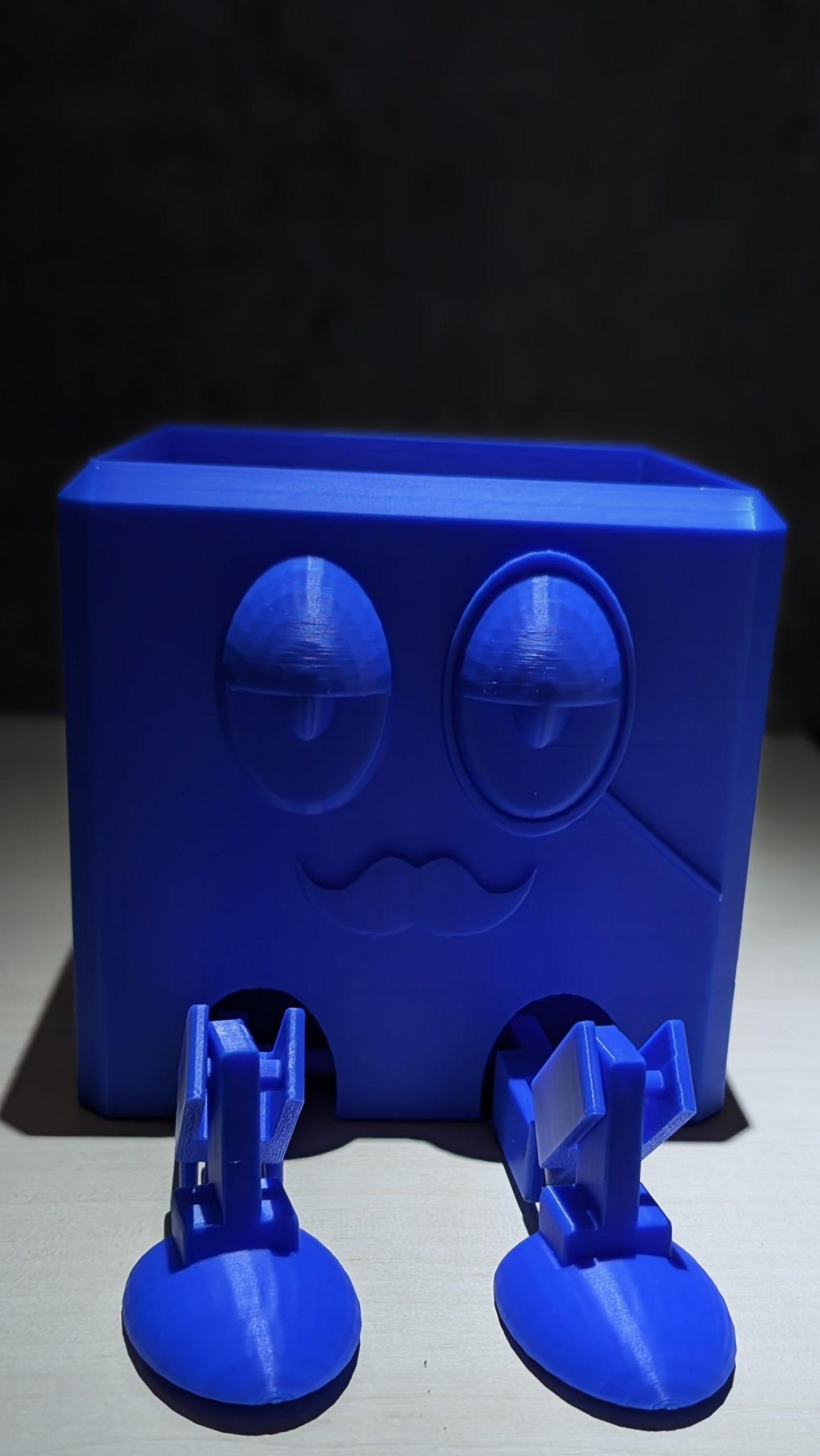 Eckiger Organizer in Blau mit Gesicht und beweglichen Beinen